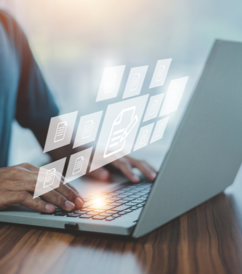 Main tapant sur un clavier d'ordinateur portable avec des icônes numériques de documents flottant à l'écran, symbolisant la gestion numérique des fichiers